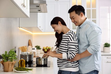 Photo of Happy lovely couple cooking together in kitchen