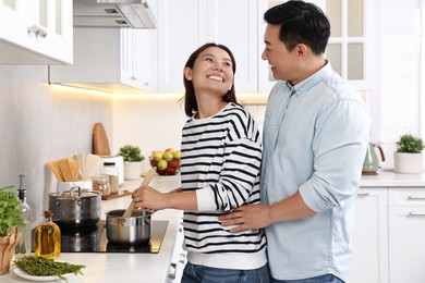 Photo of Happy lovely couple cooking together in kitchen