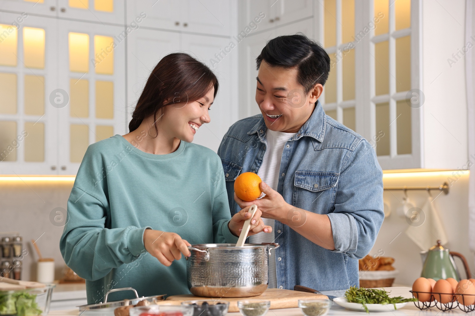 Photo of Happy lovely couple cooking together in kitchen