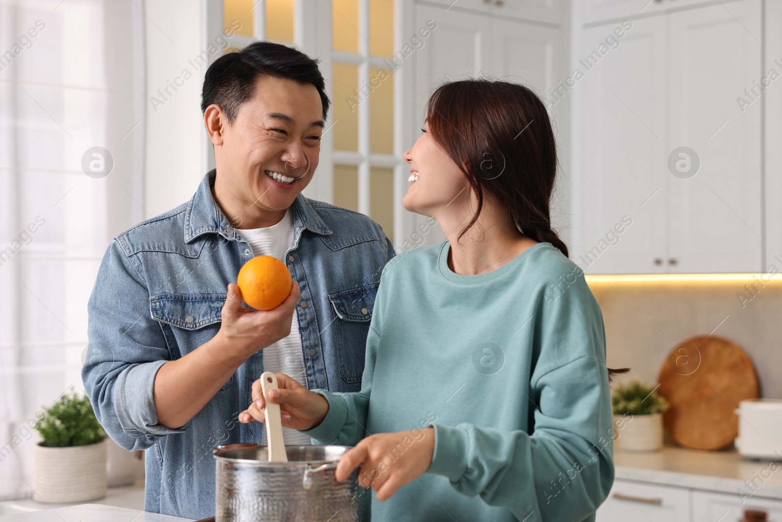 Photo of Happy lovely couple cooking together in kitchen