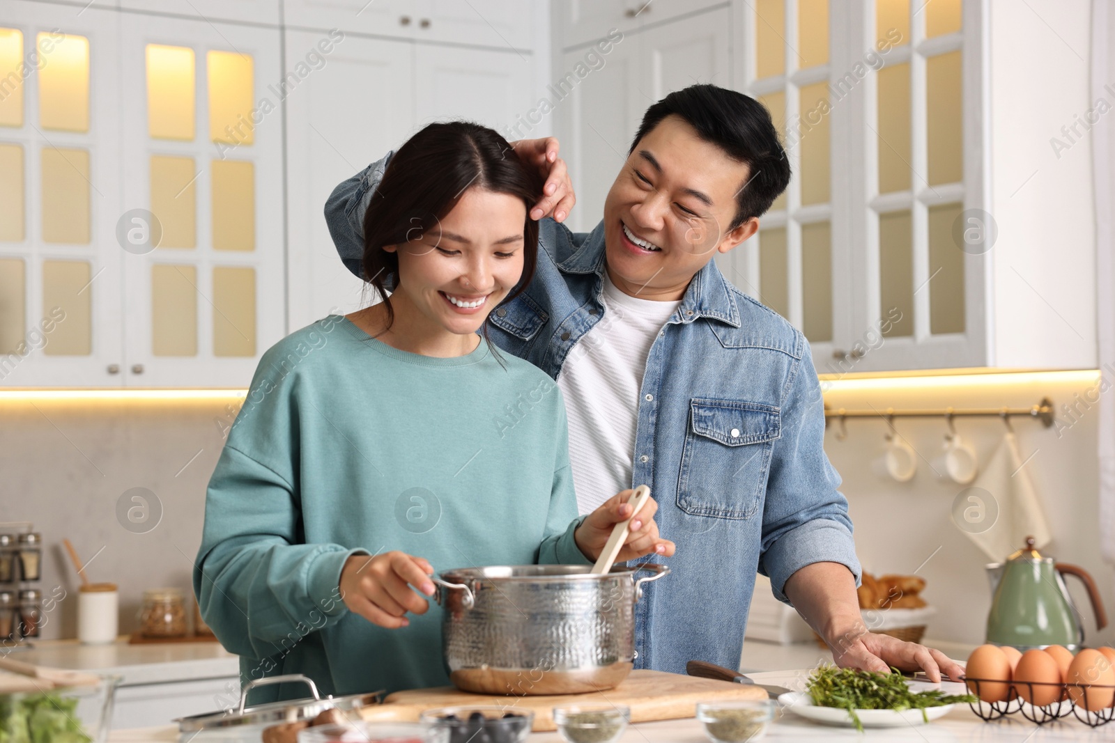 Photo of Happy lovely couple cooking together in kitchen