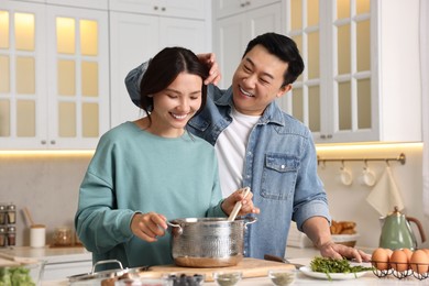 Happy lovely couple cooking together in kitchen