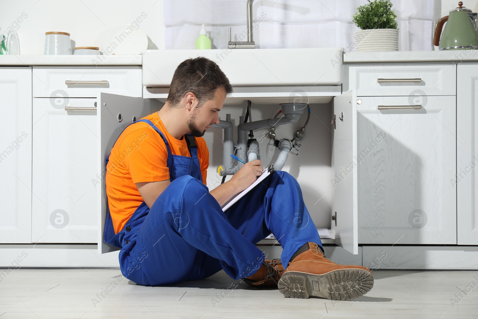 Photo of Professional plumber fixing piping system at home