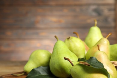 Photo of Fresh green pears and leaves on table, closeup. Space for text