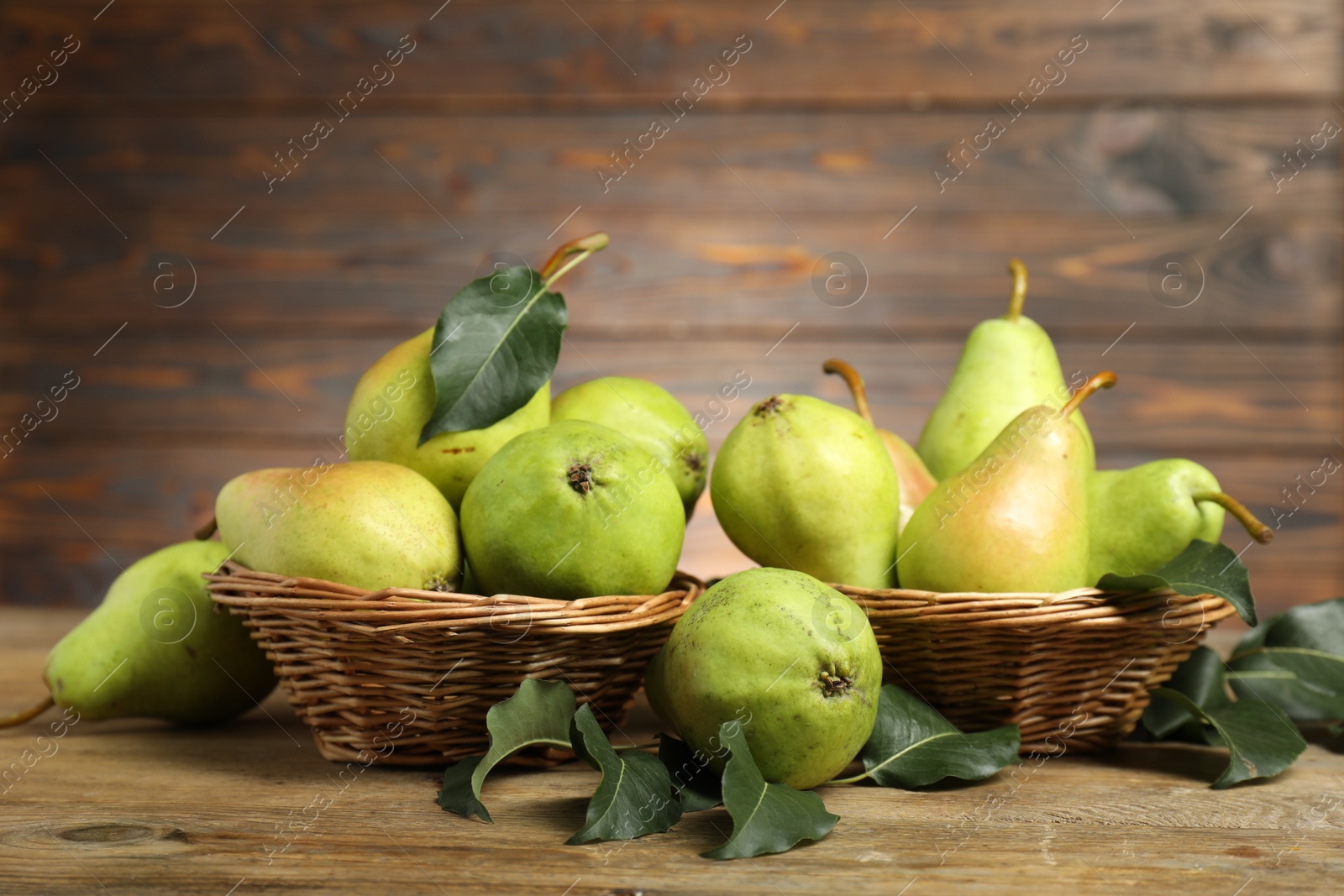 Photo of Fresh green pears and leaves on wooden table