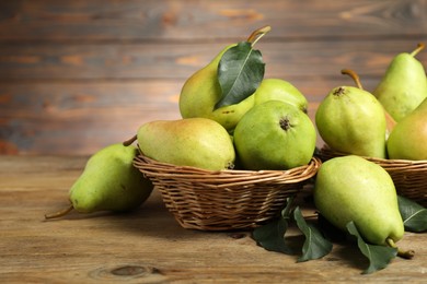 Photo of Fresh green pears and leaves on wooden table, closeup