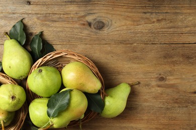 Photo of Fresh green pears and leaves on wooden table, flat lay. Space for text