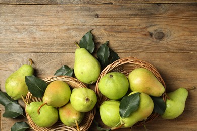 Photo of Fresh green pears and leaves on wooden table, flat lay. Space for text