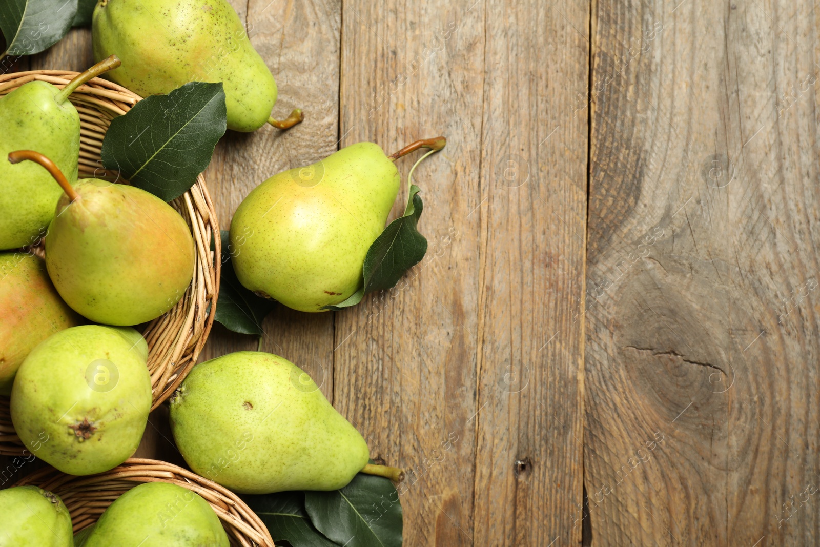 Photo of Fresh green pears and leaves on wooden table, flat lay. Space for text