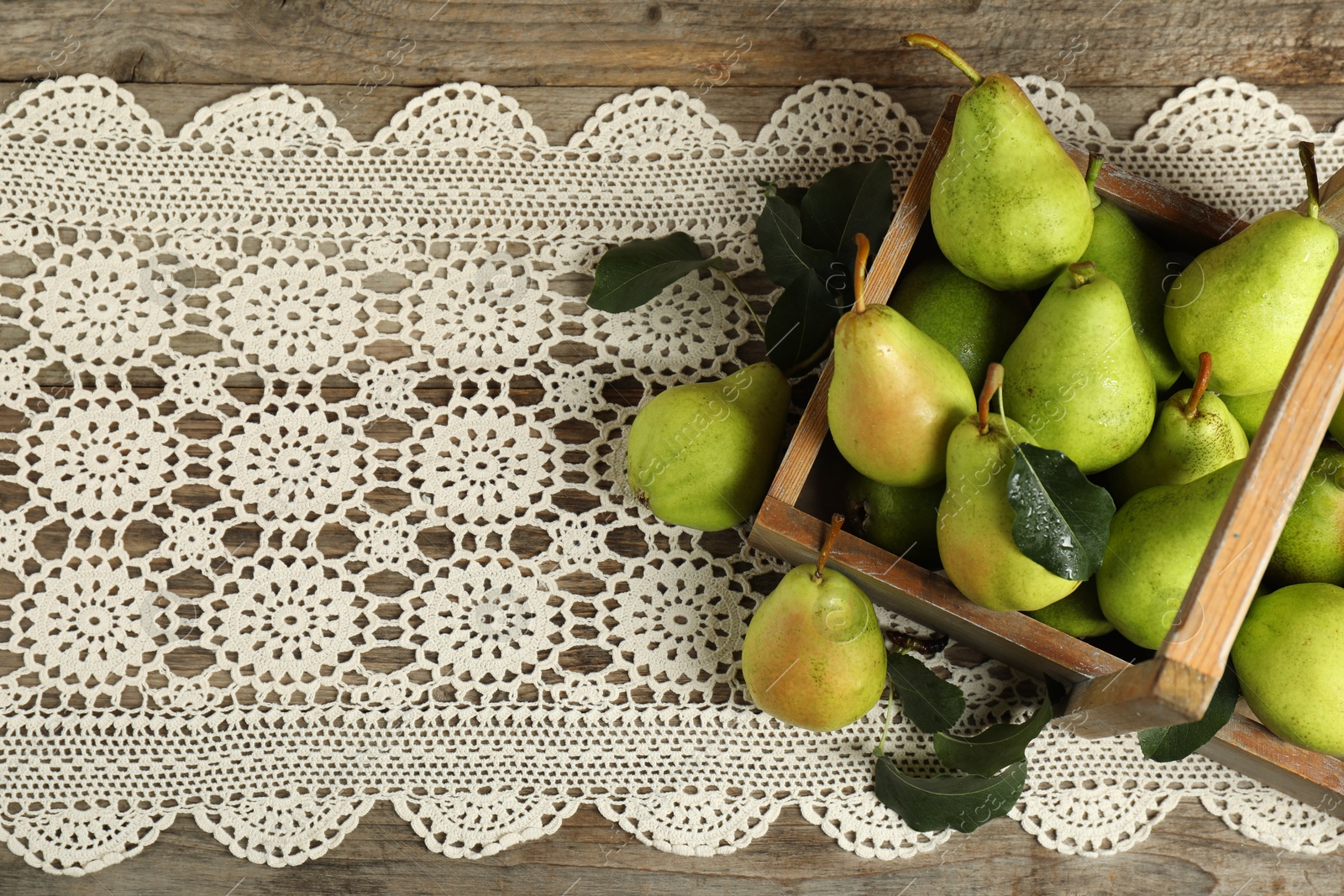 Photo of Crate with fresh green pears and leaves on wooden table, flat lay. Space for text