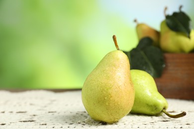 Photo of Fresh pears with water drops on wooden table against blurred green background, closeup. Space for text