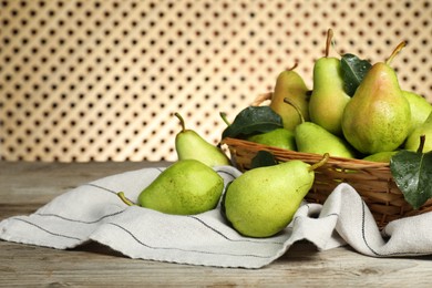 Photo of Fresh green pears and leaves with water drops on wooden table. Space for text