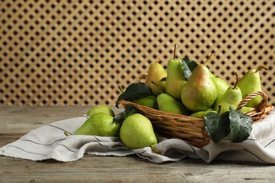 Photo of Fresh green pears and leaves with water drops on wooden table. Space for text