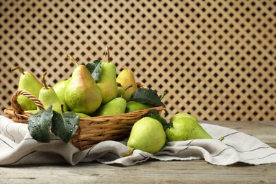 Photo of Fresh green pears and leaves with water drops on wooden table. Space for text