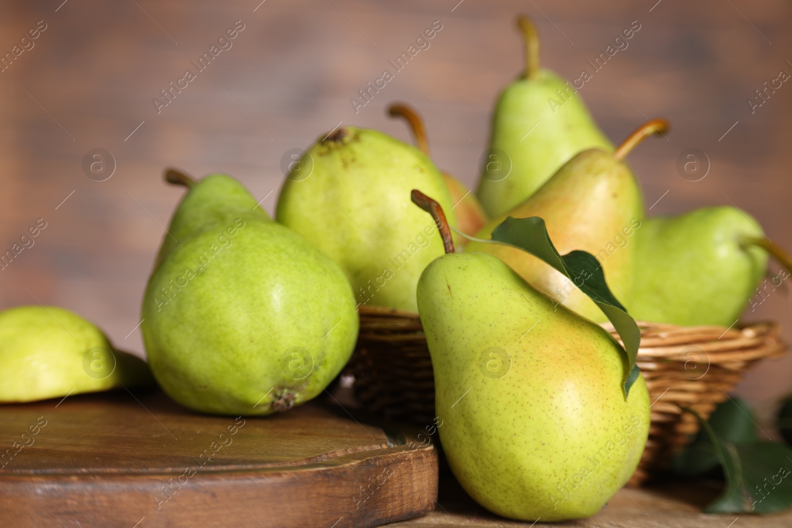 Photo of Fresh green pears and leaf on wooden table, closeup