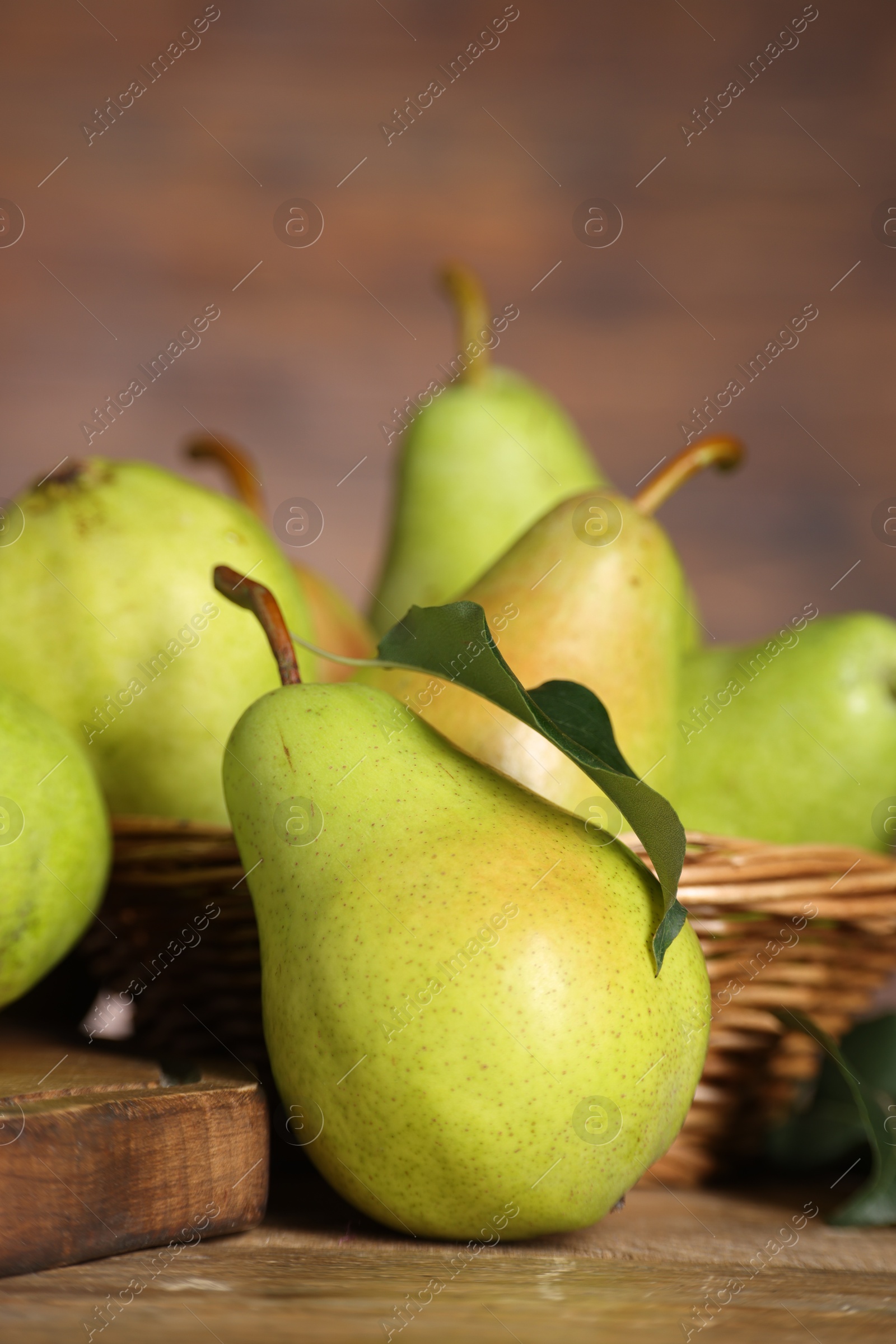 Photo of Fresh green pears and leaf on wooden table, closeup