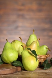 Photo of Fresh green pears and leaves on wooden table. Space for text