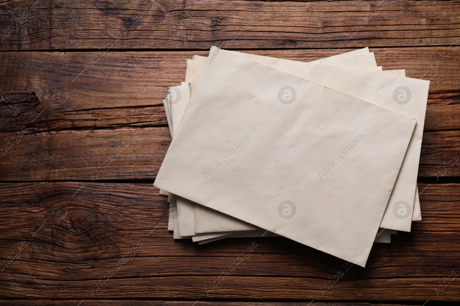 Photo of Old letter envelopes on wooden table, top view