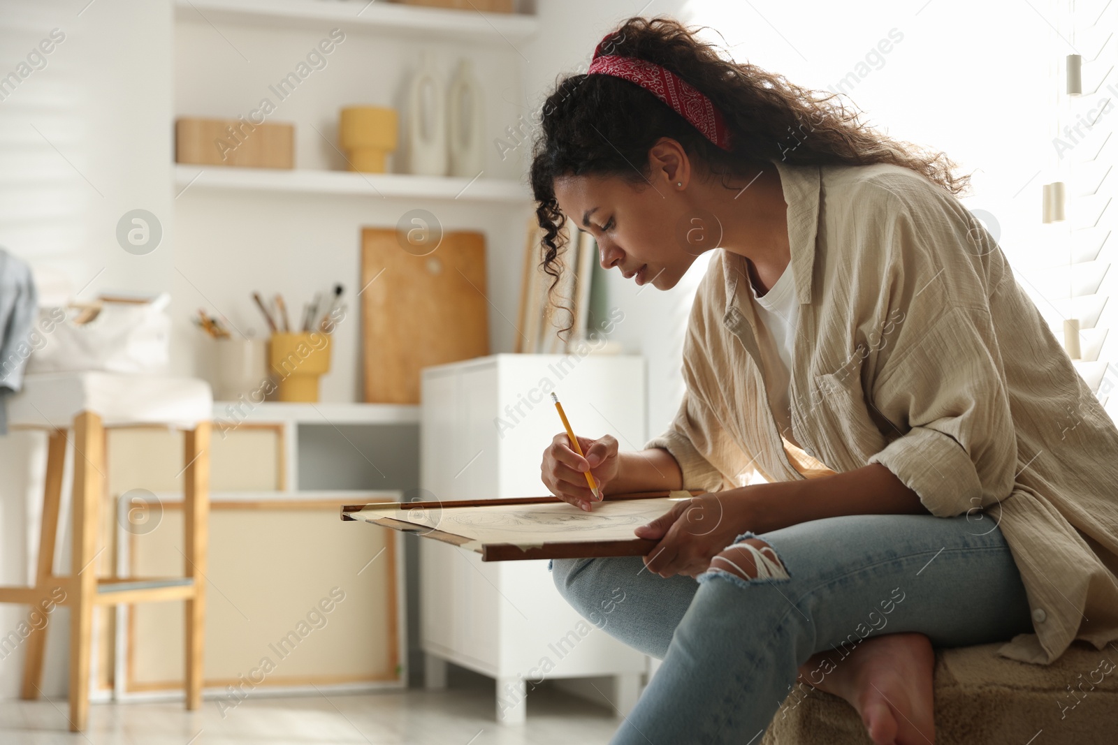 Photo of Beautiful woman drawing portrait with pencil in studio