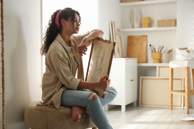 Beautiful woman with portrait in drawing studio