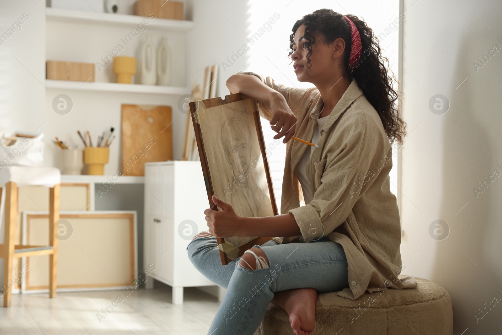 Photo of Beautiful woman with portrait in drawing studio