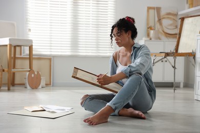 Woman drawing picture with pencil on floor in studio