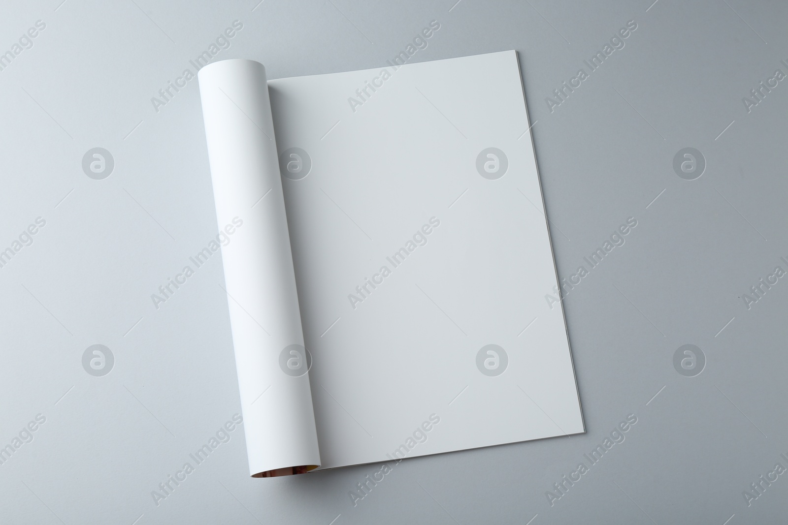 Photo of Open magazine with blank page on grey background, top view. Mockup for design