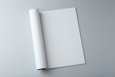 Photo of Open magazine with blank page on grey background, top view. Mockup for design