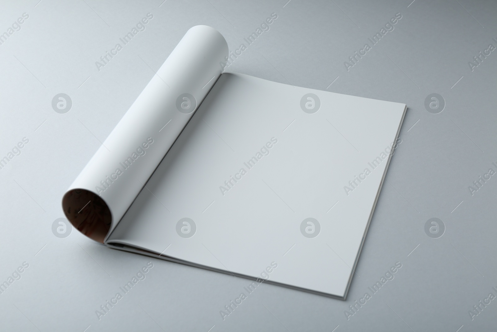 Photo of Open magazine with blank page on grey background. Mockup for design