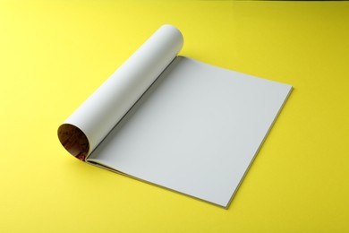 Photo of Open magazine with blank page on yellow background. Mockup for design