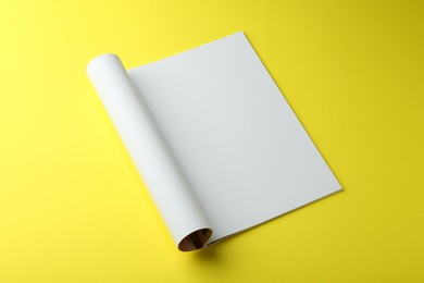 Photo of Open magazine with blank page on yellow background. Mockup for design