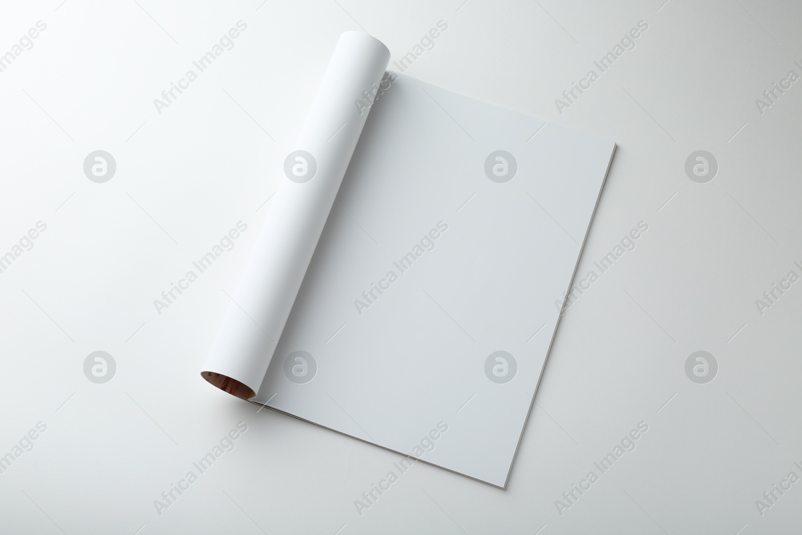 Photo of Open magazine with blank page on white background, top view. Mockup for design