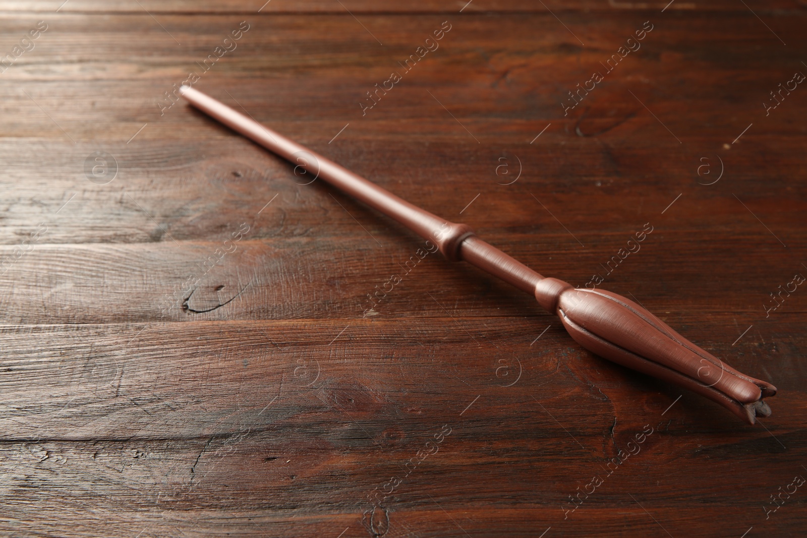 Photo of One old magic wand on wooden table, closeup