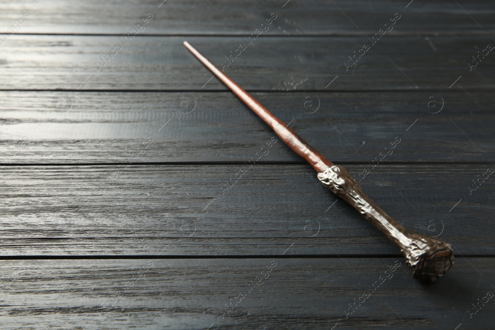 Photo of One old magic wand on wooden table, closeup. Space for text