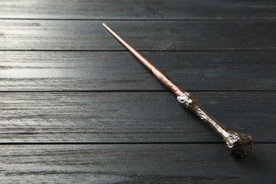 One old magic wand on wooden table, closeup. Space for text