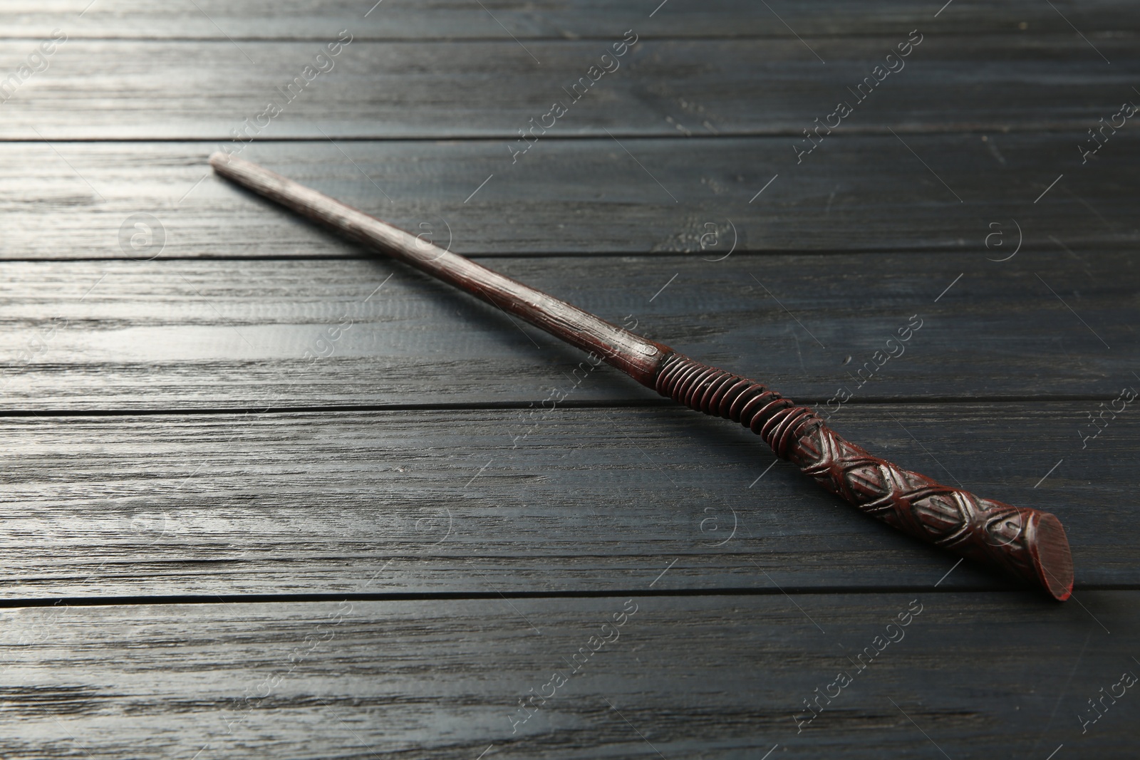 Photo of One old magic wand on wooden table, closeup