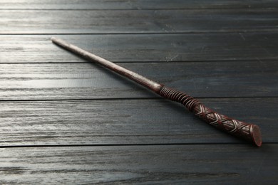 One old magic wand on wooden table, closeup