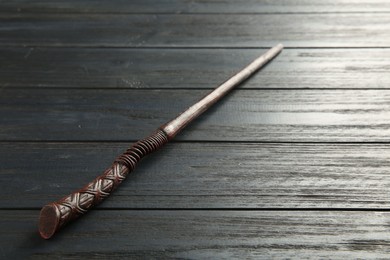 Photo of One old magic wand on wooden table, closeup