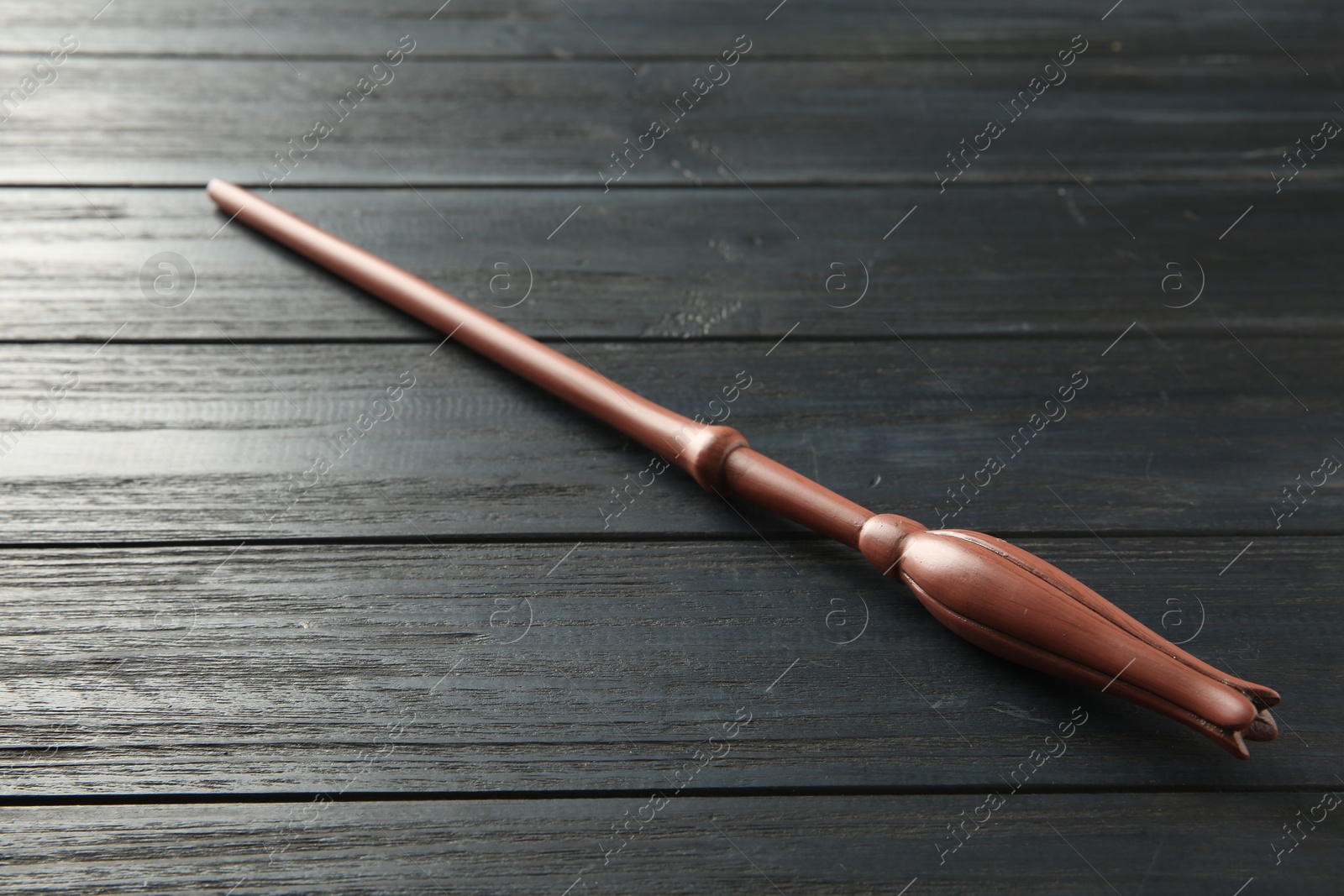 Photo of One old magic wand on wooden table, closeup