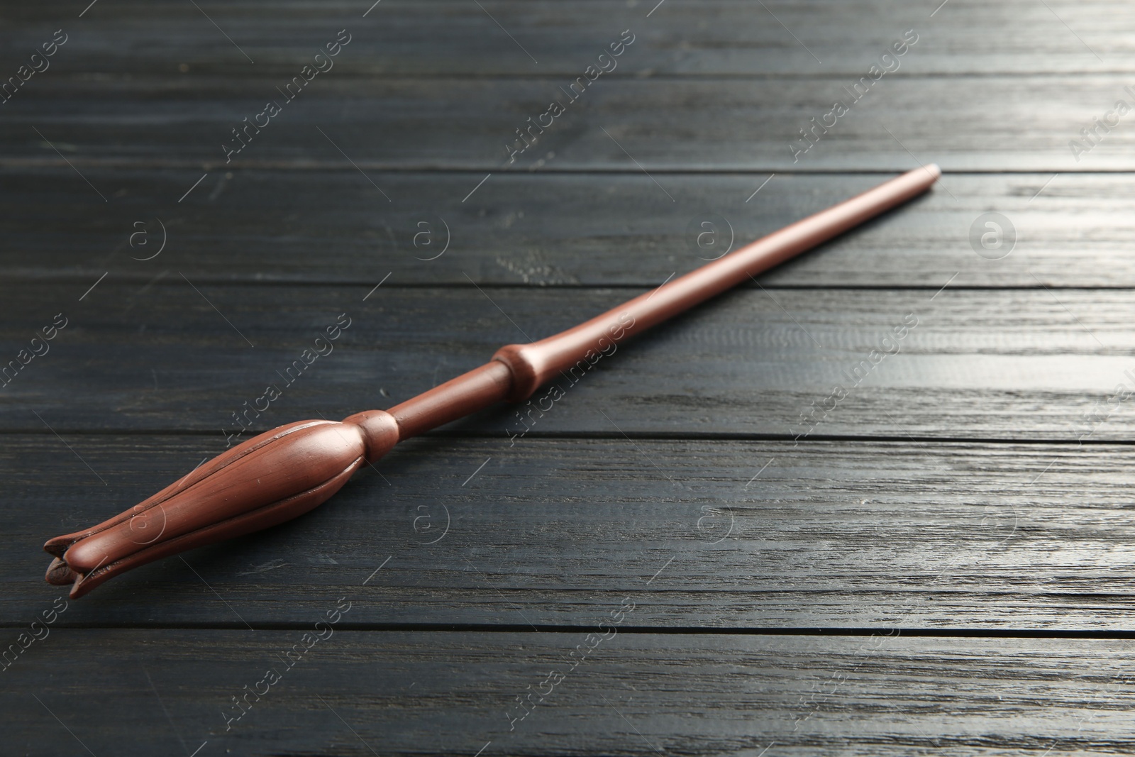 Photo of One old magic wand on wooden table, closeup