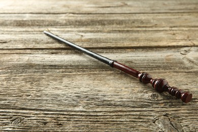 Photo of One old magic wand on wooden table, closeup