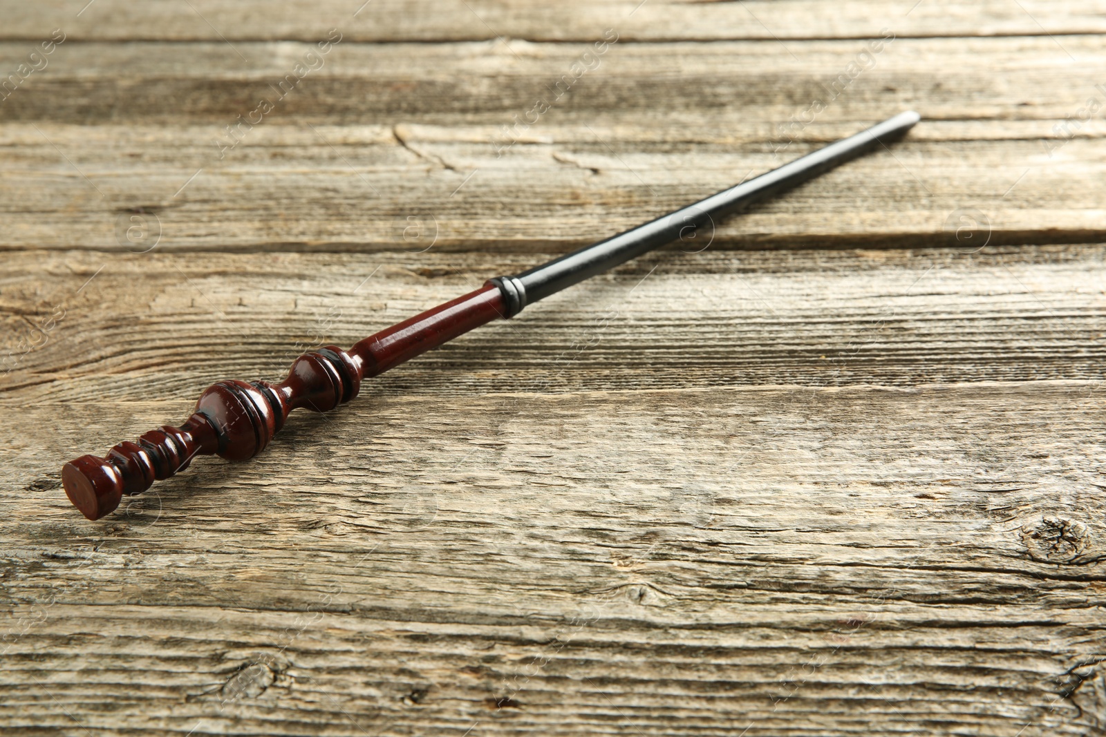 Photo of One old magic wand on wooden table, closeup