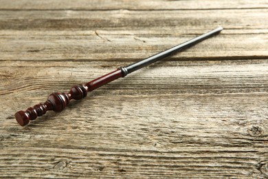 One old magic wand on wooden table, closeup