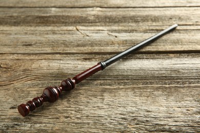 Photo of One old magic wand on wooden table, closeup