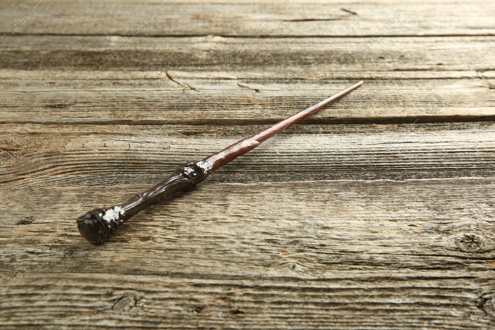 Photo of One old magic wand on wooden table, closeup