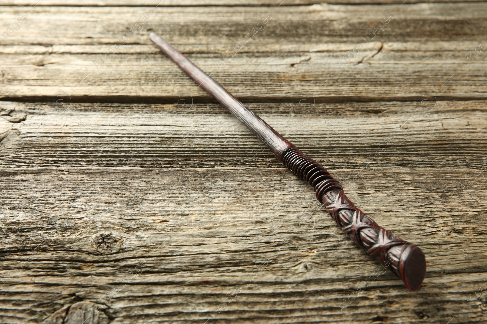 Photo of One old magic wand on wooden table, closeup