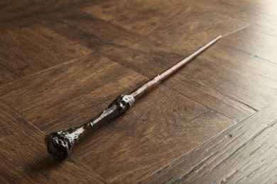 Photo of One magic wand on wooden table, closeup