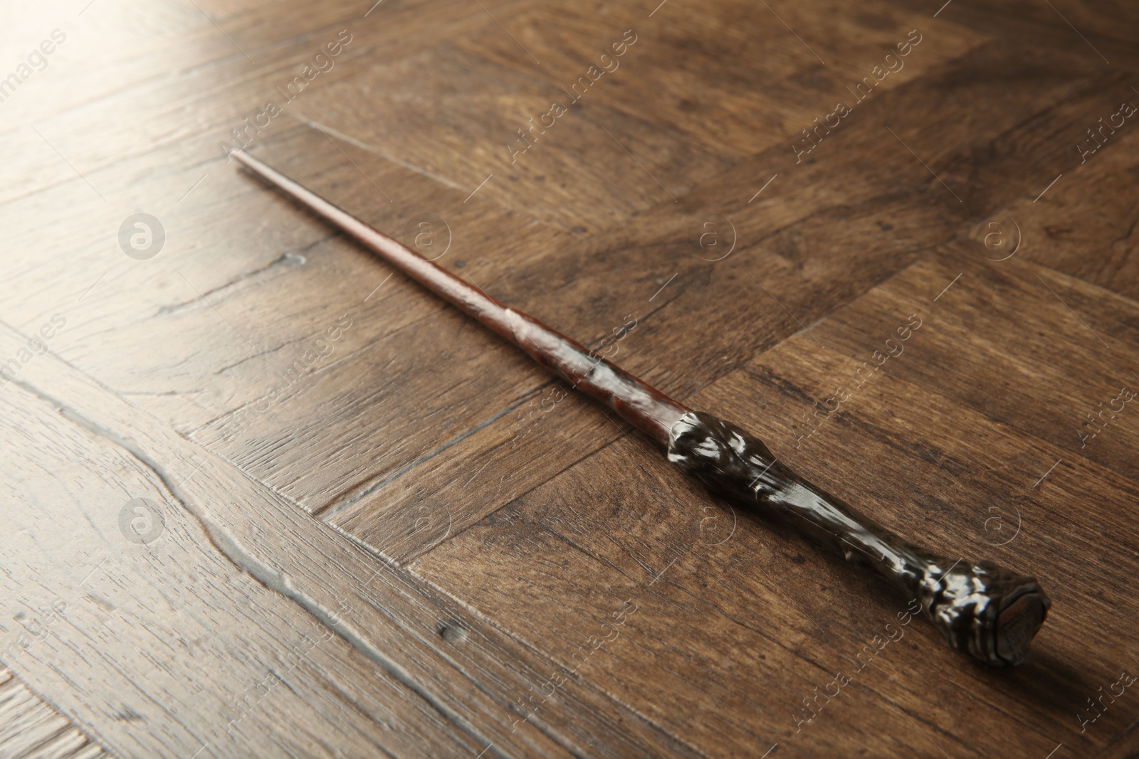 Photo of One magic wand on wooden table, closeup