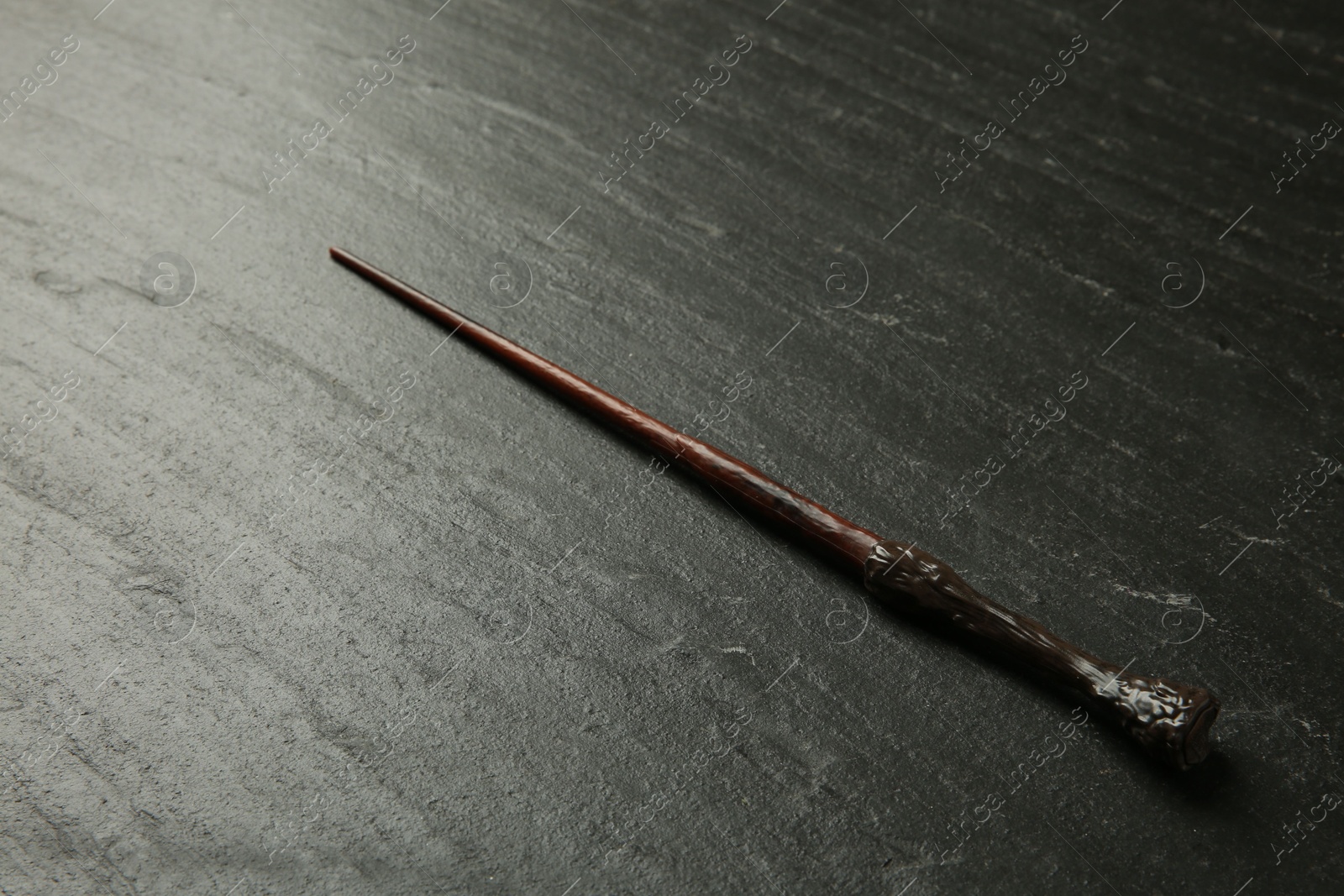 Photo of One old magic wand on black table, closeup