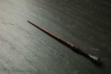 Photo of One old magic wand on black table, closeup